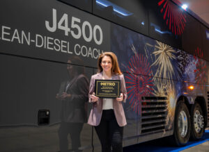 Danielle Veronesi, Senior Director of Marketing, holding the 2025 Motorcoach Operator of the Year award from METRO Magazine at the UMA Expo in Oklahoma City.
